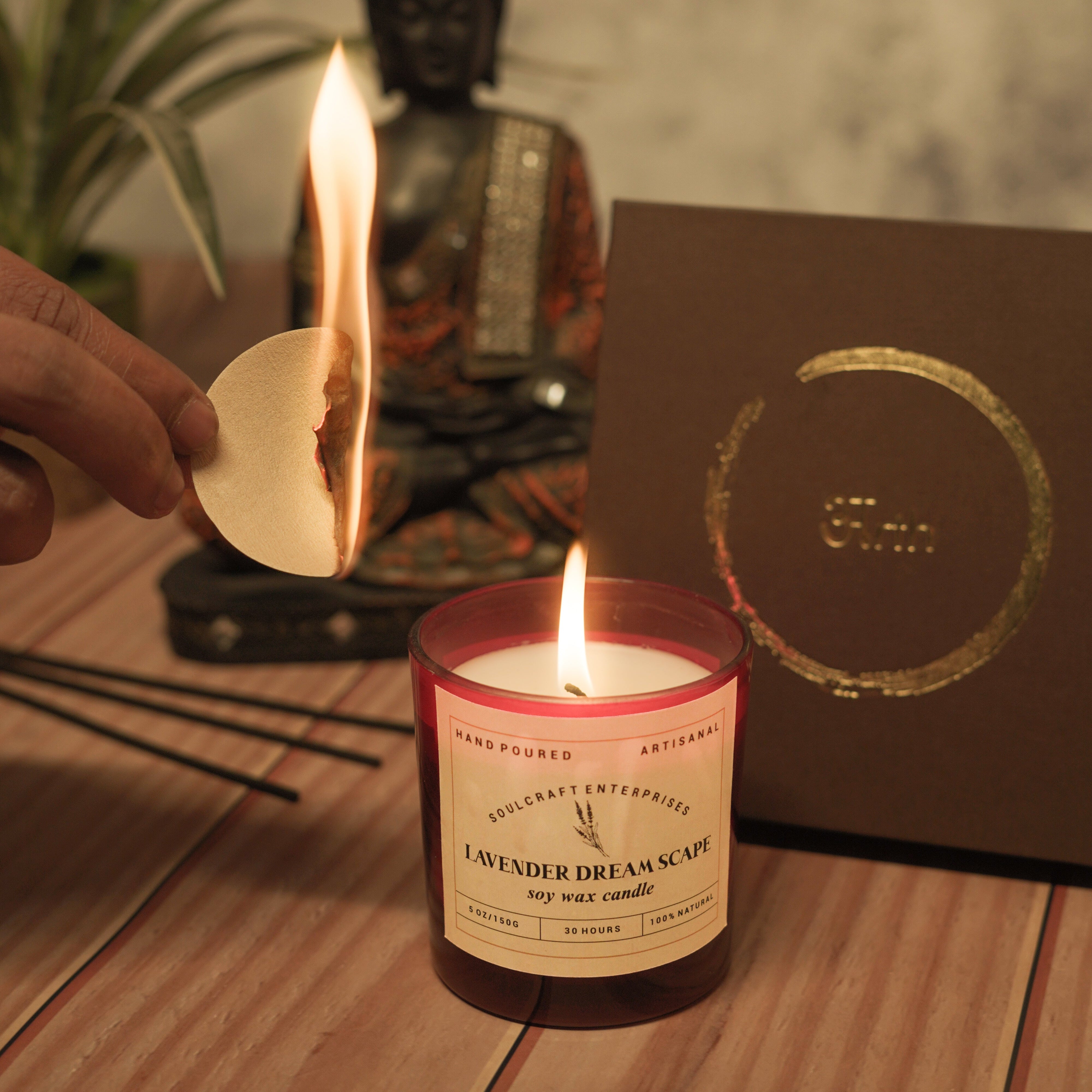 Candle being lit with a Buddha statue and card in the background